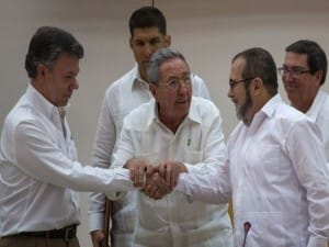El presidente de Colombia, Juan Manuel Santos, y el líder de la guerrilla de las FARC, Rodrigo Londoño (alias Timochenko) sellan el pacto con un apretón de manos con el presidente cubano Raul Castro Como Testigo. 